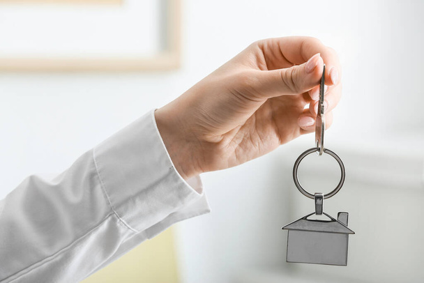 Женщина с ключом от дома в помещении - Фото, изображение