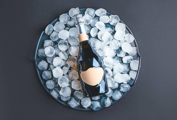 Пляшка шампанського та кубиків льоду на темному фоні
 - Фото, зображення
