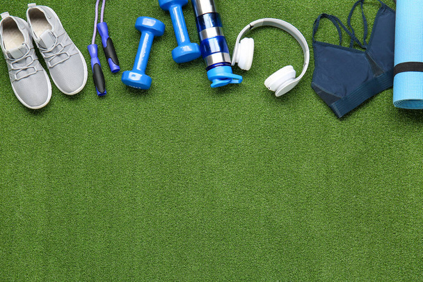 Sportieve apparatuur, fles water en koptelefoon op kleur achtergrond - Foto, afbeelding
