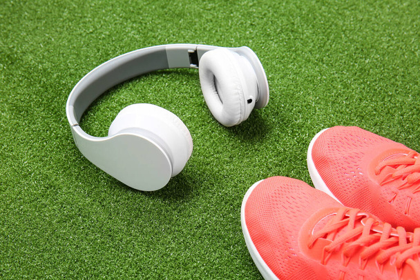 Sportowe buty i słuchawki na tle koloru - Zdjęcie, obraz