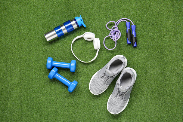 Sportive equipment and headphones on color background - Photo, Image