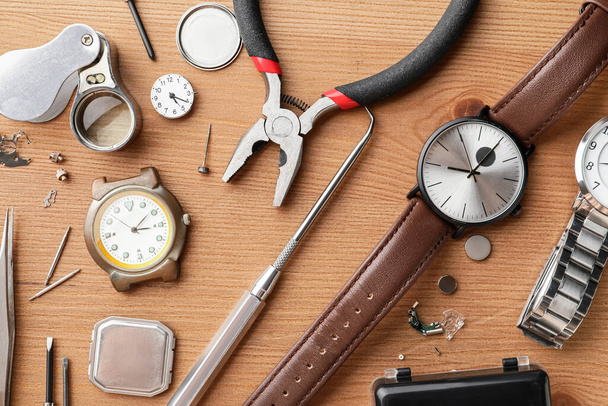 Ρολόγια και εργαλεία για την επισκευή σε ξύλινο φόντο - Φωτογραφία, εικόνα