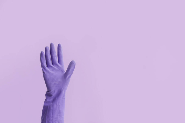 Χέρι σε λαστιχένιο γάντι στο φόντο χρώμα - Φωτογραφία, εικόνα
