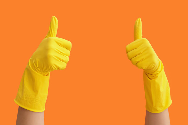 Ręce w gumowych rękawiczkach pokazujących kciuk do góry na kolorowym tle - Zdjęcie, obraz