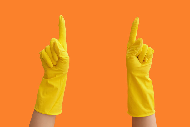 Hände in Gummihandschuhen zeigen auf etwas auf farbigem Hintergrund - Foto, Bild