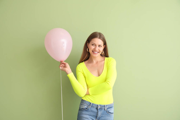 Young woman with balloon on color background - Foto, imagen