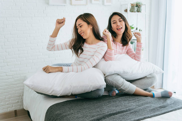 Two pretty best friends forever girlfriend talk, hug and laugh together on bed at cozy home relation fall in love. Lesbian couple homosexual happy lifestyle on bed. LGBTQ relation lifestyle concept. - Фото, изображение