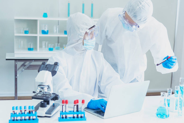 Dois asiáticos cientista equipe reservam química ciência tubo experimento biotecnologia amostra de anticorpos em laboratório Cultivate Vacina contra o vírus covid-19. Cientista consultar, analisar no laboratório de química - Foto, Imagem
