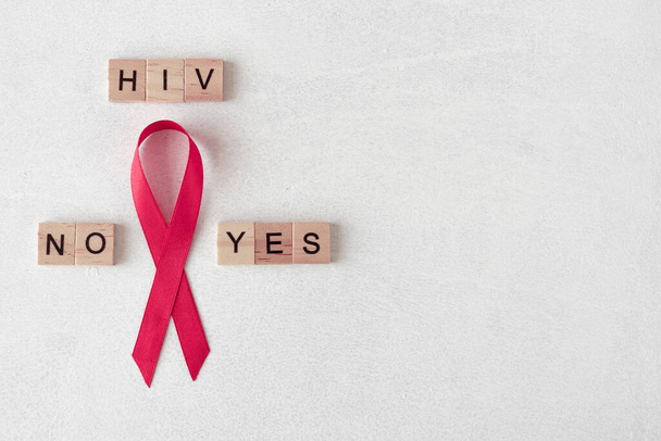 世界エイズデー。木製の文字の近くに赤いリボン。HIV検査の概念。良い結果も悪い結果も。バナー - 写真・画像