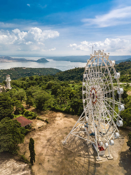 Aerial of Tagaytay Picnic Grove - Una grande ruota panoramica, un parco e Taal vulcano e lago sullo sfondo. - Foto, immagini
