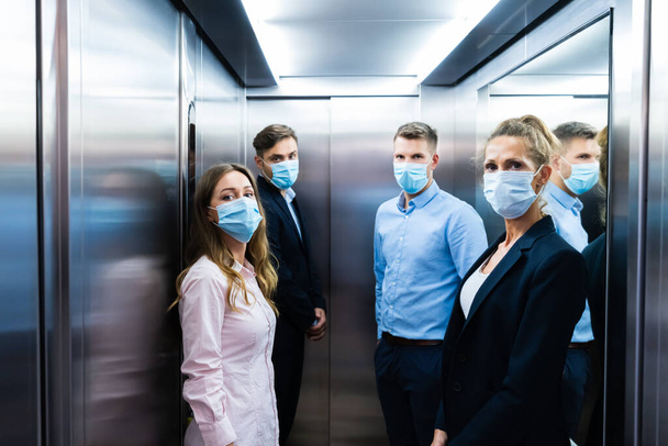 Grupo de personas en ascensor con máscaras faciales - Foto, imagen