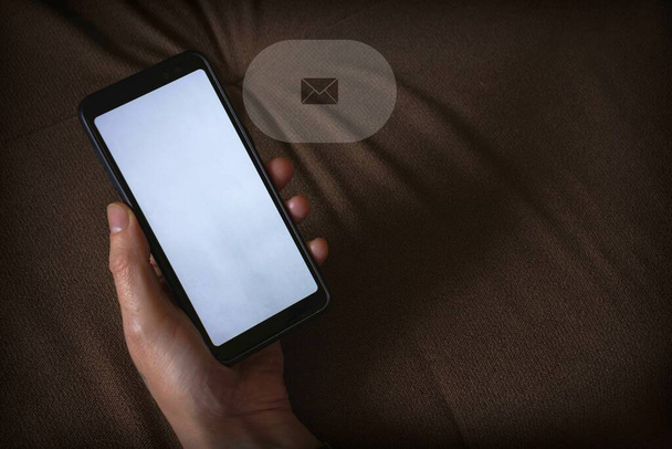 Akıllı telefon maketi. Beyaz ekran ve posta ikonu olan siyah bir telefonu tutan bir el. Boşluğu kopyala - Fotoğraf, Görsel