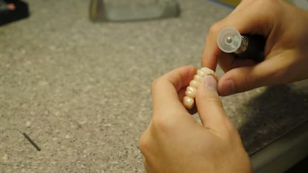 Стоматолог ручной мельницы зубные коронки. Зубной техник держит искусственную челюсть плесени с зубами, работающих с керамической коронки полировки в стоматологической лаборатории. 4 k видео - Кадры, видео