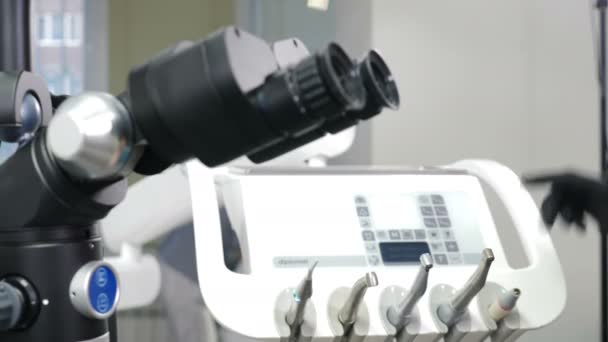 Moderna clinica odontoiatrica con microscopio per pazienti in trattamento. Medico mano in guanto protettivo toccare attrezzature mediche. Presentazione di attrezzature in Clinica moderna. 4K filmati - Filmati, video