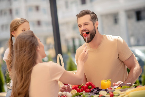 Young wife feeding her husband with tomato - Photo, image