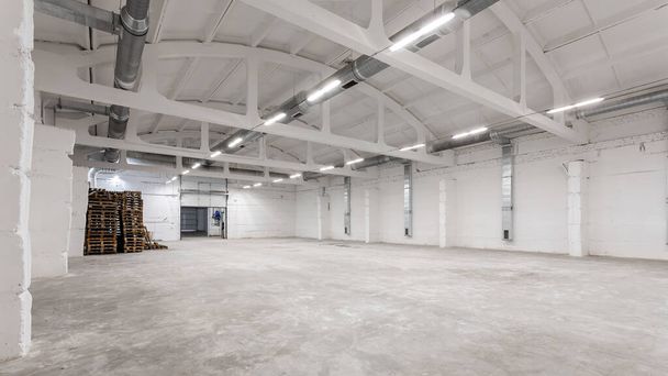 Interior del edificio industrial con paredes de ladrillo blanco, suelo de hormigón y espacio vacío para exposición de productos o fondo industrial - Foto, imagen