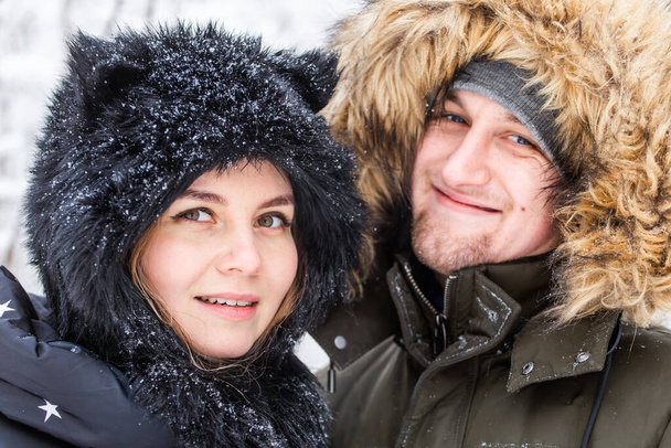 Young couple in love have fun in the snowy forest. Active winter holidays. - Fotografie, Obrázek