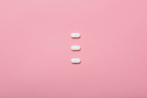Píldoras de la medicina y la droga sobre fondo rosa colorido con copyspace, concepto de atención médica mínima. - Foto, imagen