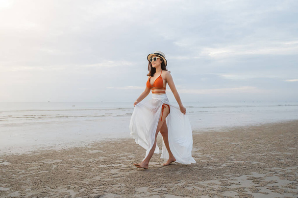 cheerful woman in bikini walking on the sea beach - Фото, зображення