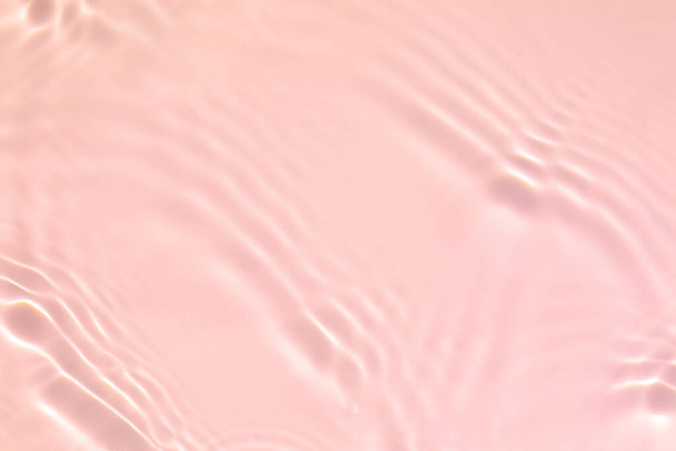 Closeup of pink transparent clear calm water surface texture with splashes and bubbles. Trendy abstract summer nature background. Coral colored waves in sunlight. - Photo, Image