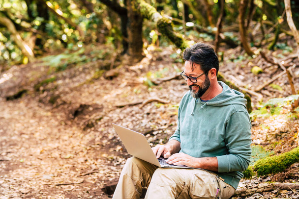 Hombre adulto trabaja al aire libre con computadora portátil, concepto de trabajo inteligente nómada digital y libre de gente moderna de oficina  - Foto, imagen