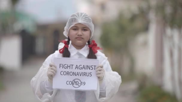 COVID-19 Coronavirus- Vírus mortal: Menina vestindo máscara, luvas e vestido de proteção em uniforme escolar para a segurança contra COVID-19 Coronavirus. Apple ProRes 422.Girl espalhando a conscientização - Filmagem, Vídeo