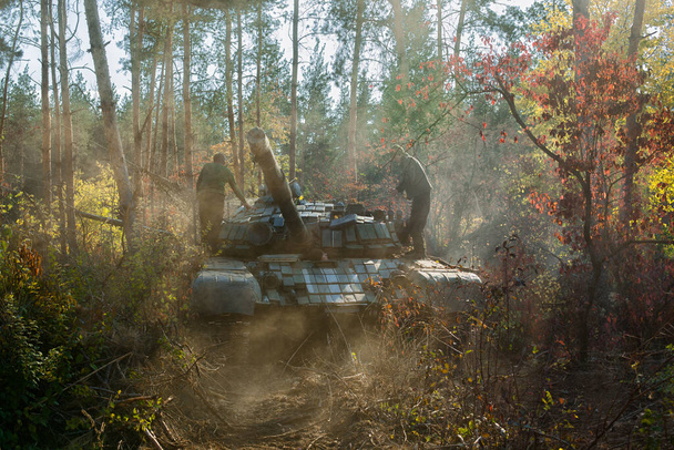 танк Т-64 в облаках пыли в осеннем лесу - Фото, изображение