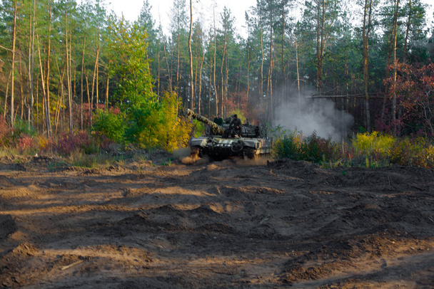 real battle panzer   in the Donbass - eastern Ukraine is driving fast in a coniferous forest - Photo, Image