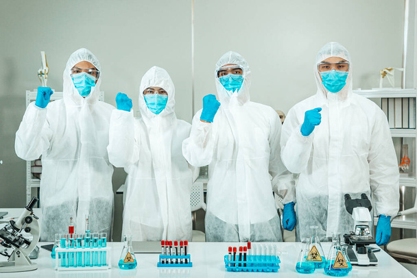 Ομάδα επιστημόνων ιατρικής έρευνας που εργάζονται με κοστούμι PPE. - Φωτογραφία, εικόνα