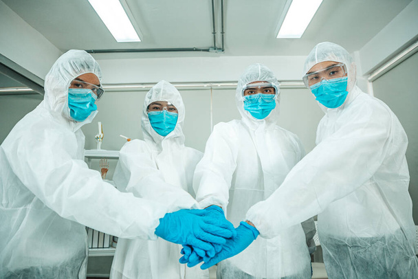 Team van medische onderzoekers werkzaam in PPE-pak. - Foto, afbeelding