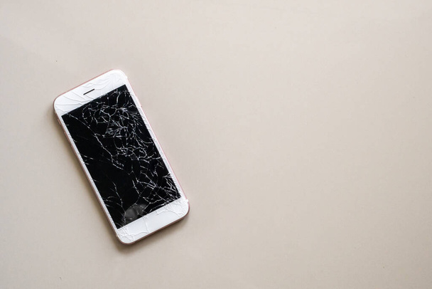 broken glass of mobile phone screen on tile floor background - Photo, image