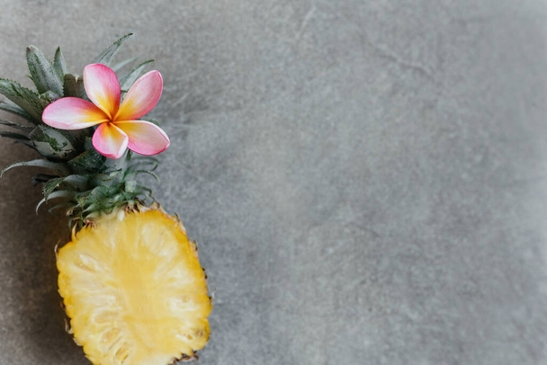 Pineapple and frangipania on a stone table. Tropical Fruits. - Foto, Bild