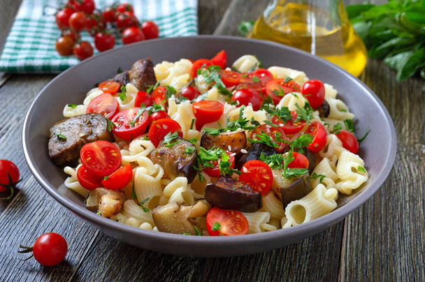 Pasta creste with grilled eggplant, cherry tomatoes and herbs. Delicious warm salad.  - Photo, Image