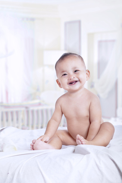 Attractive baby laughing in the bedroom - Foto, imagen