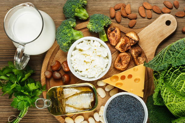 Foods rich in calcium such as sardines, bean, dried figs, almonds, cottage cheese, hazelnuts, parsley leaves, blue poppy seed, broccoli, italian cabbage, cheese, milk - Photo, Image