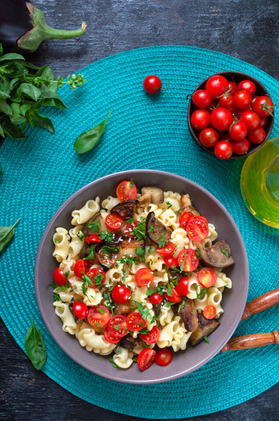 Pasta creste with grilled eggplant, cherry tomatoes and herbs. Delicious warm salad. - Photo, Image