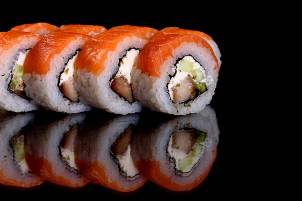 Fresh delicious beautiful sushi rolls on a dark background. Elements of Japanese cuisine - Photo, Image