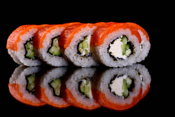 Friss, ízletes, gyönyörű sushi tekercsek sötét háttérrel. A japán konyha elemei - Fotó, kép