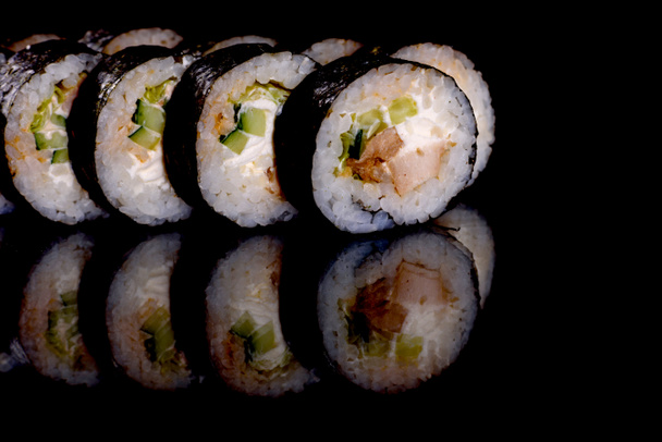 Verse heerlijke mooie sushi broodjes op een donkere achtergrond. Elementen van de Japanse keuken - Foto, afbeelding