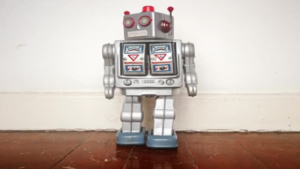 robot de plata retro moviendo la cabeza y bailando en un viejo movimiento de parada de piso de madera - Imágenes, Vídeo