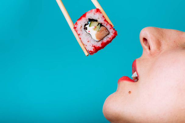 Close up macro of lips with Sushi roll. Lady eating japanese food. - Foto, imagen