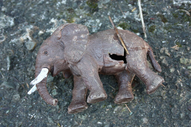 ein trauriges braunes Elefantenspielzeug, das auf einer Straße ausgesetzt wurde - Foto, Bild