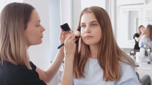 Profesional maquillaje artista utiliza cepillo grande para apllies tono o polvo - Metraje, vídeo