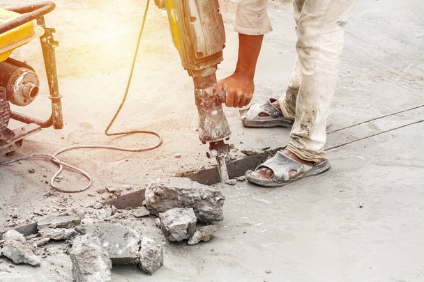 Trabajador de la construcción utilizando martillo neumático perforación superficie de hormigón - Foto, imagen