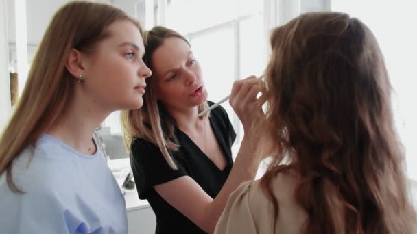 Ενηλίκων επαγγελματίας δάσκαλος visagiste εκπαίδευση νέων μαθητών της για να γίνει καλλιτέχνης μακιγιάζ στο master class στο σαλόνι ομορφιάς. - Πλάνα, βίντεο