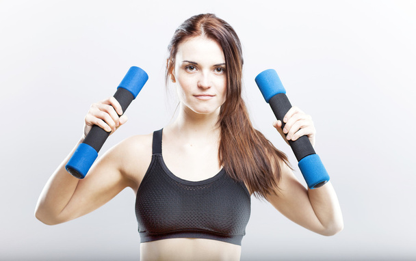 Young fit woman training with dumbbells - Foto, immagini