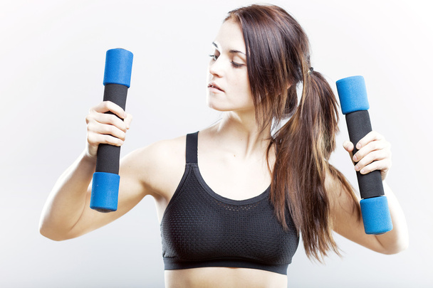 Young fit woman training with dumbbells - Foto, immagini