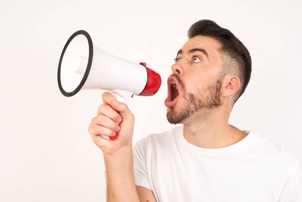 young caucasian man wearing casual clothes shouting loud holding a megaphone, expressing success and positive concept, idea for marketing or sales. - Foto, afbeelding