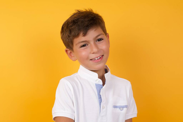 cute boy  smiling    against yellow  wall   - Foto, afbeelding