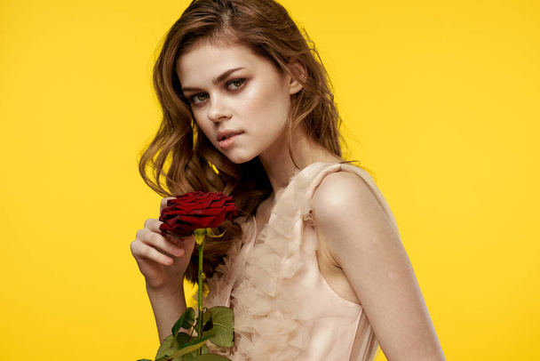 Nice girl with red rose on yellow background cropped view of emotion model - Photo, Image